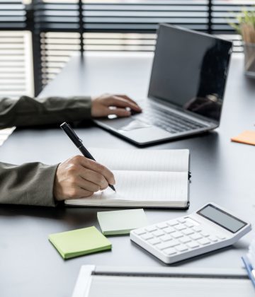 księgowa przy laptopie i kalkulatorze – biuro rachunkowe